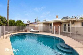 Tucson house for rent - a large pool in front of a house with a fence around it