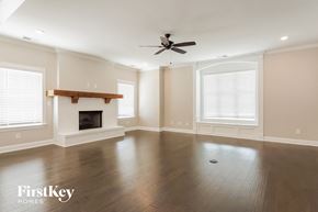 Helena house for rent - an empty living room with a fireplace and a ceiling fan