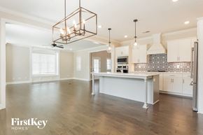 Helena house for rent - an open kitchen and dining room with a large island and a chandelier