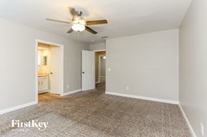 Jacksonville house for rent - a living room with a ceiling fan and a carpeted floor