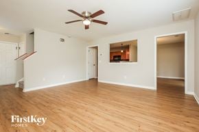 Ladson house for rent - A spacious room with a ceiling fan and wooden flooring.