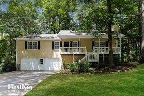 Canton house for rent - a yellow house with a white garage door and a porch