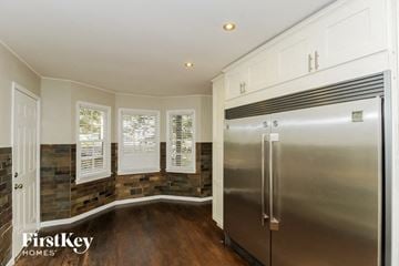 Canton house for rent - a kitchen with a stainless steel refrigerator and white cabinets