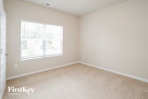 Canton house for rent - a bedroom with a large window and beige carpet