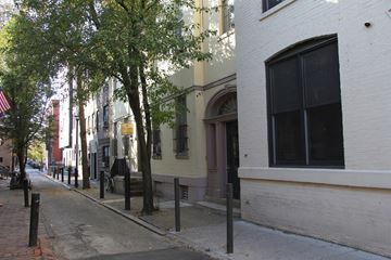 Philadelphia apartment for rent - a city street with a white brick building and trees