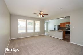 Richmond house for rent - A spacious living room with a ceiling fan and a kitchen area in the background.