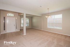 Richmond house for rent - A spacious room with a carpeted floor and a chandelier hanging from the ceiling.