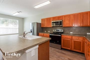Richmond house for rent - A kitchen with orange cabinets and a stainless steel oven.