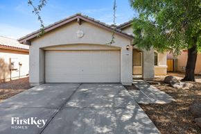 Laveen house for rent - A house with a garage door and a tree in front.