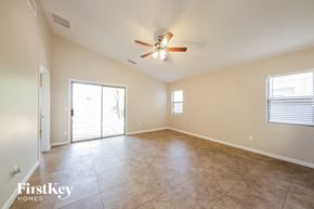 Laveen house for rent - A spacious room with a ceiling fan and sliding glass doors.