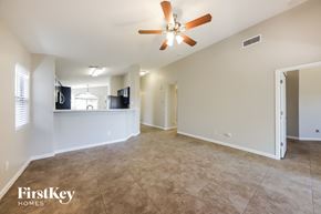 Laveen house for rent - A spacious room with a ceiling fan and a flat screen TV mounted on the wall.
