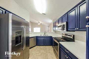 Laveen house for rent - A kitchen with blue cabinets and a stainless steel refrigerator.