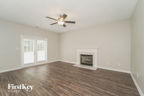 Concord house for rent - A room with a fireplace and a ceiling fan.