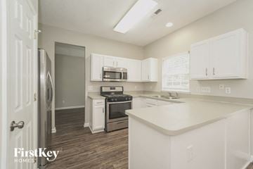Concord house for rent - A kitchen with white cabinets and a white island.