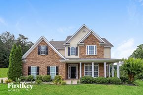 Cartersville house for rent - A brick house with a porch and a tree in front.