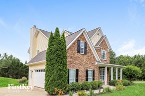 Cartersville house for rent - A brick house with a large front yard and a tall tree.