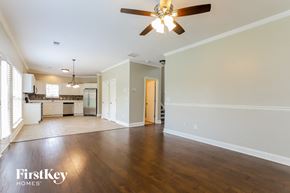 Cartersville house for rent - A spacious living room with a ceiling fan and hardwood floors.