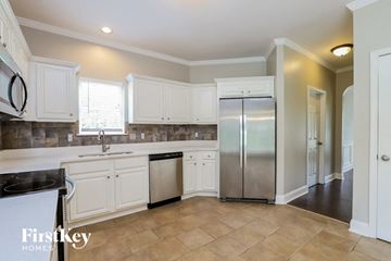 Cartersville house for rent - A kitchen with white cabinets and a tile backsplash.