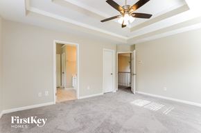 Cartersville house for rent - A spacious room with a ceiling fan and a carpeted floor.