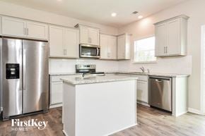 Winston-Salem house for rent - a white kitchen with stainless steel appliances and white cabinets