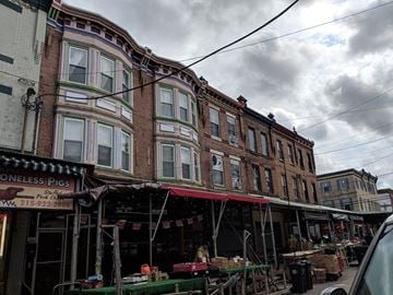 Philadelphia apartment for rent - a row of buildings on a street under a cloudy sky