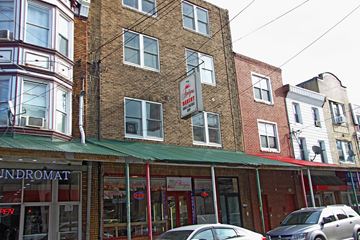Philadelphia apartment for rent - the front of a building with cars parked outside of it
