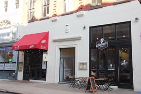 Philadelphia apartment for rent - a white building with a red awning and tables outside of it