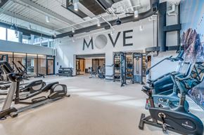 Calgary apartment for rent - A gym with a variety of exercise equipment and a large "MOVE" sign on the wall.