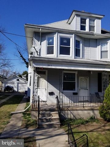 Gloucester City apartment for rent - A two-story house with a white front and a black iron fence.
