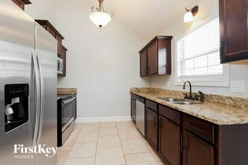 Clarksville house for rent - A kitchen with a stainless steel refrigerator and brown cabinets.