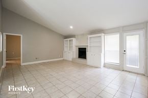 Norman house for rent - A spacious room with a fireplace and a door on the left.