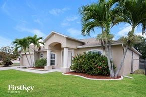 Cape Coral house for rent - a house with palm trees in front of it