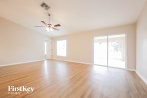 Cape Coral house for rent - an empty living room with wood floors and a ceiling fan