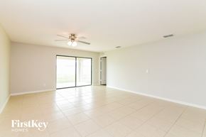 Dundee house for rent - A spacious room with a ceiling fan and sliding glass doors.