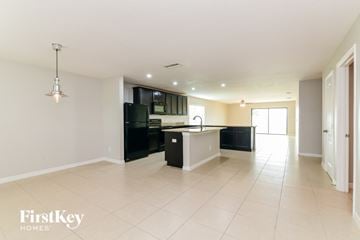 Dundee house for rent - A spacious kitchen with black appliances and white cabinets.