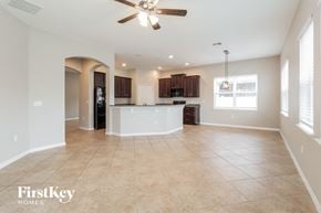 Wesley Chapel house for rent - A spacious living room with a ceiling fan and tiled flooring.