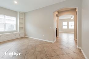 Wesley Chapel house for rent - A spacious room with a tiled floor and a large archway leading to another room.