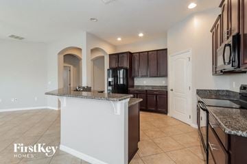 Wesley Chapel house for rent - A kitchen with a white island and brown cabinets.