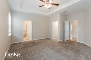 Wesley Chapel house for rent - A spacious room with a ceiling fan and carpeted floor.