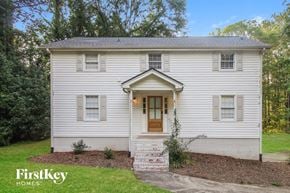 Canton house for rent - the front of a white house with a lawn and trees