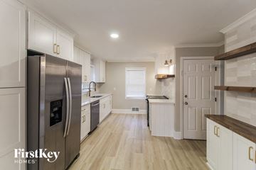 Canton house for rent - a large kitchen with white cabinets and stainless steel appliances