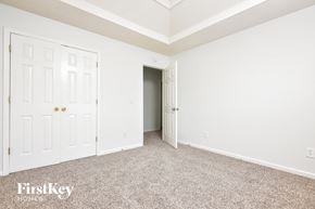 Decatur house for rent - a bedroom with white walls and carpet and a door to a closet