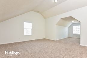 Decatur house for rent - a spacious attic room with carpeting and a window