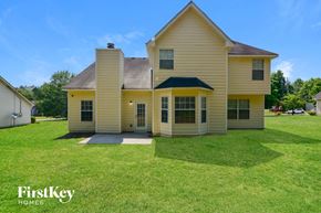 Decatur house for rent - the front of a yellow house with a grassy yard