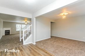 Indianapolis house for rent - A spacious room with a staircase and a fireplace.