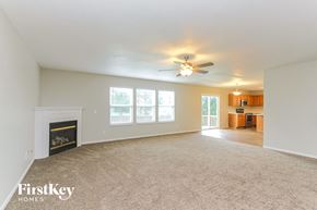Indianapolis house for rent - A spacious living room with a fireplace and a ceiling fan.