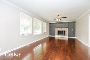 Murfreesboro house for rent - an empty living room with a fireplace and a ceiling fan