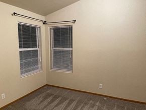 Pasco apartment for rent - A room with a carpeted floor and two windows with blinds.