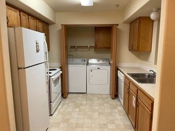 Pasco apartment for rent - A kitchen with a white refrigerator, a dishwasher, a stove, and a sink.
