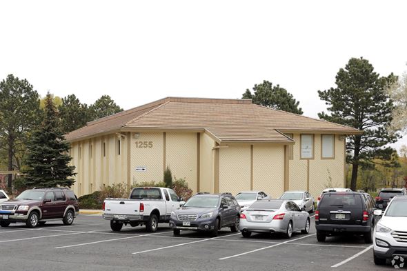 Colorado Springs apartment for rent - A parking lot with cars and a building with the number 1255.